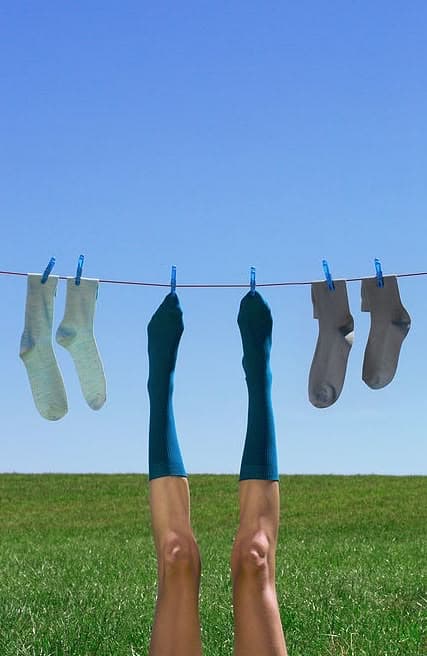 Calcetines de colores tendidos en una cuerda sobre el prado